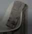 Faded grey denim jeans draped over a modern minimalist chair with soft lighting.