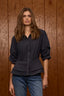 Carbon Blue Below Elbow Puff Pleated Sleeve Buttoned Cuffs Collar Neck Button Down Front Pleats Cinched Back Double Peplum Hem Woven Suede Top